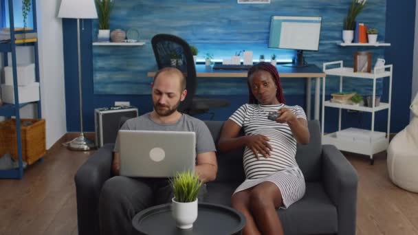 Ras campuran orang duduk bersama di sofa mengharapkan bayi — Stok Video
