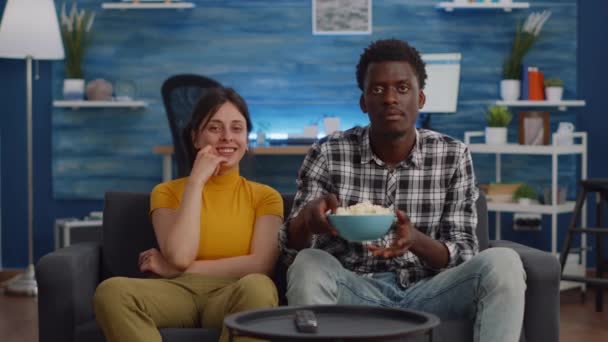 POV de pareja interracial viendo película en TV con snack — Vídeos de Stock