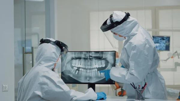Профессиональный стоматолог, рассматривающий анимацию зубов на экране — стоковое фото