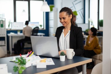 Konsantre iş kadını dizüstü bilgisayara mali raporlar yazıyor.