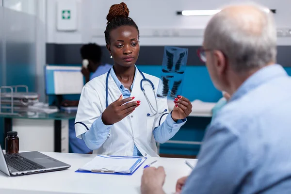 African ethnicity woman with doctor job looking at x ray scan — Stock Photo, Image