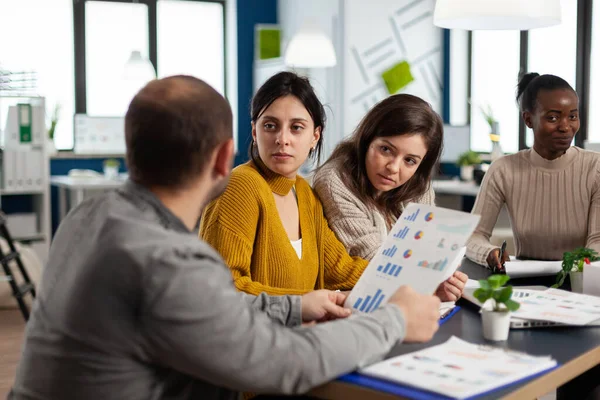 Upptagen mångkulturell kvinnlig personal som analyserar årlig finansiell statistik — Stockfoto