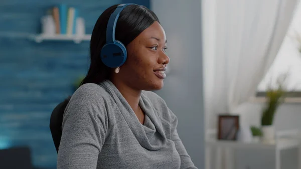 Estudante afro-americano colocando fone de ouvido na cabeça começar a ouvir música relaxante — Fotografia de Stock