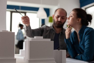 Çalışan mimar meslektaşları proje planlarını tartışıyor