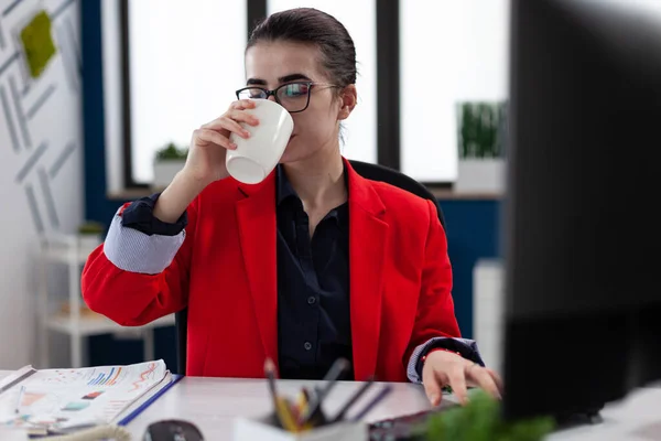 Zakenvrouw neemt een slokje koffie werken in het hoofdkantoor — Stockfoto