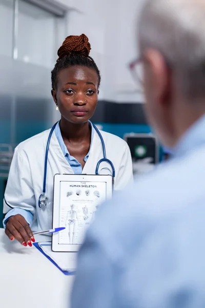 Afrykański amerykański lekarz trzymający ilustrację na ekranie tabletki — Zdjęcie stockowe