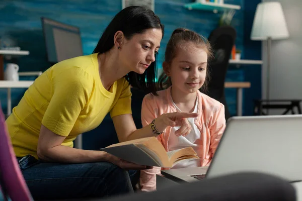 Caucasian mother helping girl with homework project
