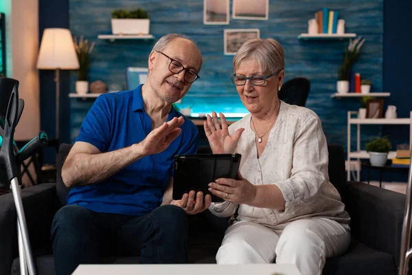 Oude man en vrouw zwaaien op video bellen met behulp van tablet — Stockfoto