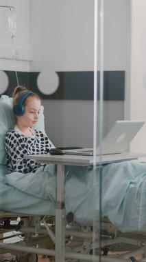 Kulaklık takıp yatakta dinlenen oksijen tüplü hasta kız.