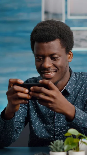 African american man playing video games on his phone — Stock Photo, Image