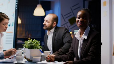 Fazla mesai yapan not defterine yatırım stratejisi yazan Afrikalı Amerikalı kadın portresi