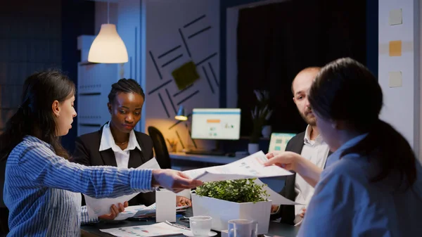 Diversos empresarios multiétnicos que comparten gráficos de gestión con exceso de trabajo en la sala de reuniones de la oficina — Foto de Stock