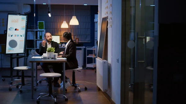 Multi-ethnic businesspeople working overtime in office meeting room — Stock Photo, Image