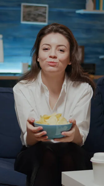 Portret van een blanke vrouw die chips eet uit een kom. — Stockfoto