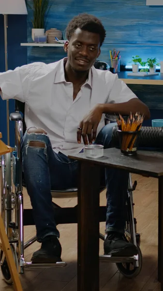 Uomo afroamericano seduto sulla sedia a rotelle mentre disegna — Foto Stock