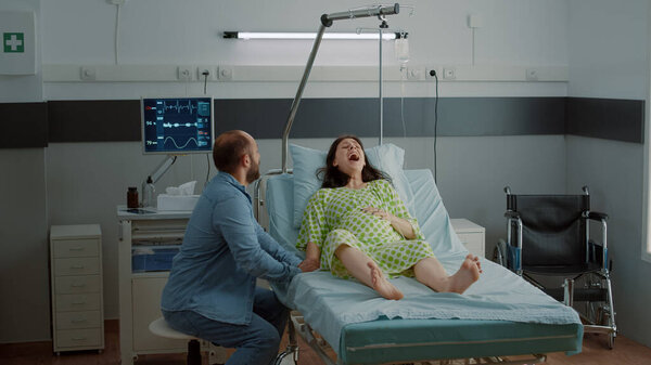 Young man panicking while pregnant wife having contractions