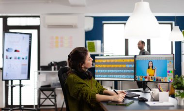 Yaratıcı fotoğrafçı dijital rötuş programını kullanıyor, kulaklık takıyor.