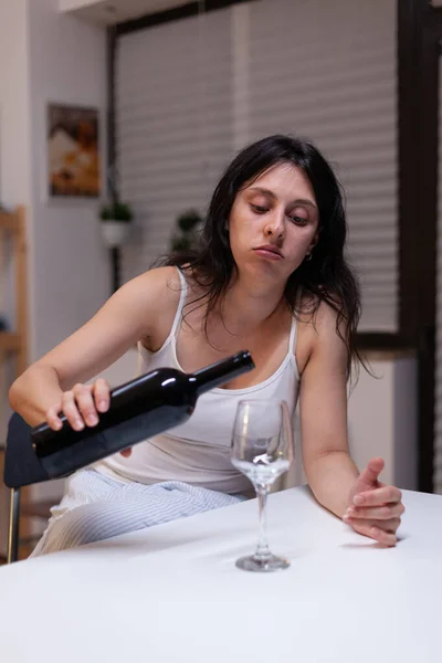 Adulto joven bebiendo vino solo en la cocina en casa —  Fotos de Stock