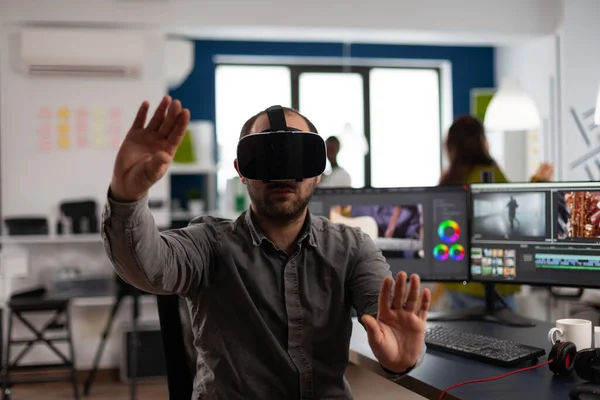 Criador de designer usando fones de ouvido VR gesticulando durante a edição do projeto de montagem — Fotografia de Stock