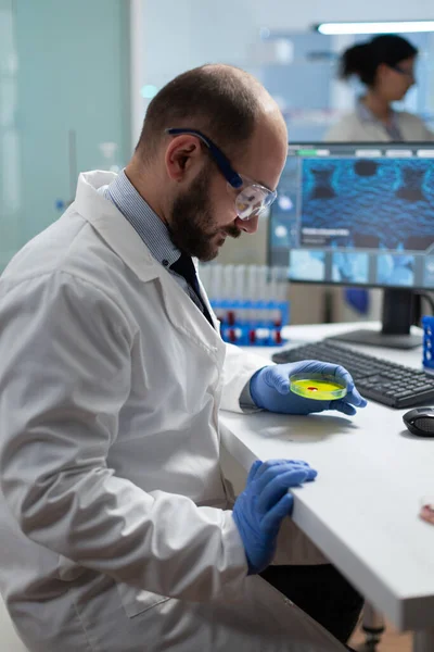 Biólogo hombre sosteniendo placa petri médica con muestra de bacterias —  Fotos de Stock