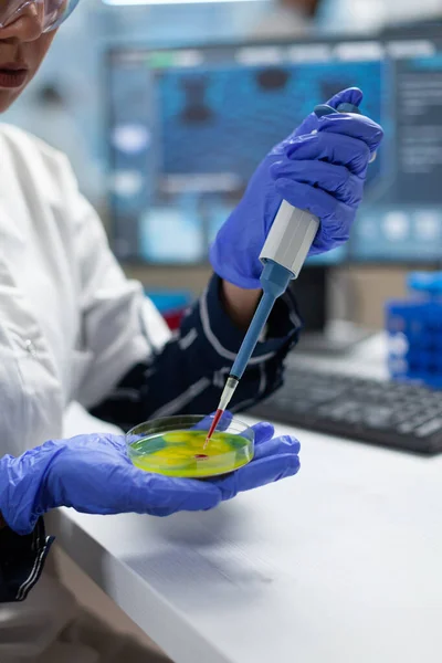Закрыть руки исследователя-биолога и положить образец жидкости в чашку Петри — стоковое фото
