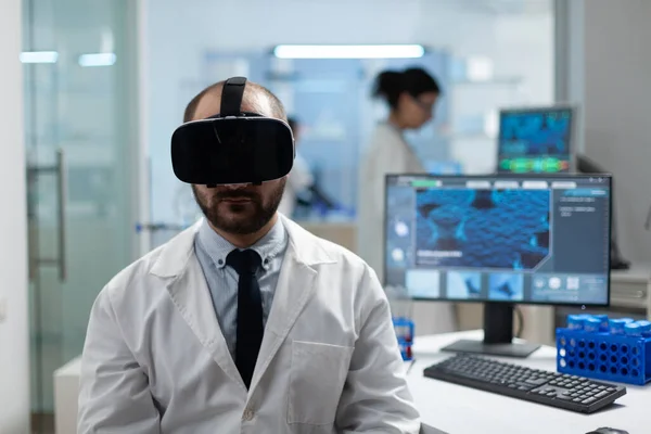 Chercheur chimiste analysant le développement de la maladie en utilisant un casque de réalité virtuelle — Photo