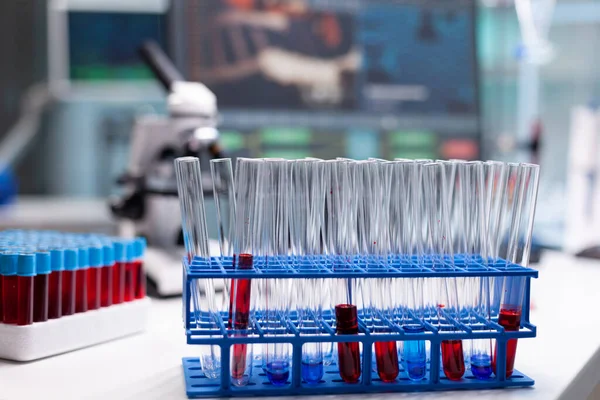 Tube à essai médical avec échantillon de sang debout sur la table pendant l'examen pharmaceutique — Photo