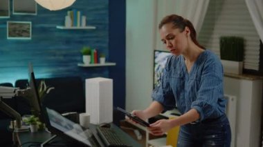Tablet tutan kadın mimar planları analiz ediyor