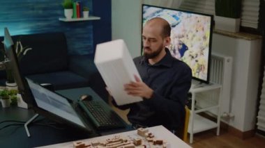 Genç mühendis maketi tutuyor ve inşaatta çalışıyor.