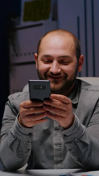 Unternehmer lächelt am Telefon, während er Finanzstrategie-Planer schreibt — Stockfoto