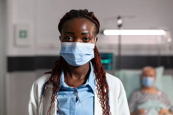 Médico afro-americano especialista em cuidados de saúde usando máscara quiral — Fotografia de Stock