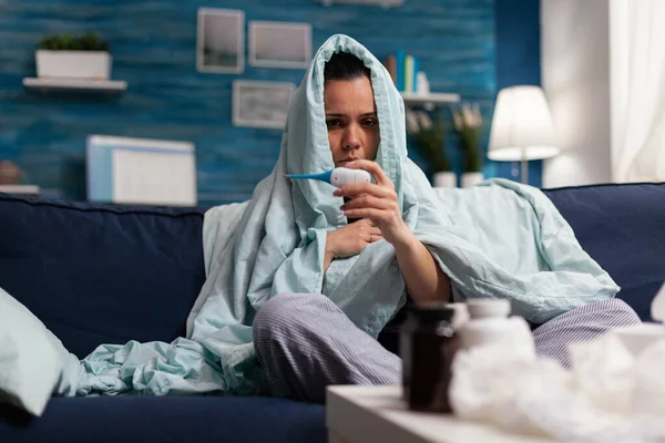 Mujer joven con síntomas de gripe comprobando la temperatura — Foto de Stock