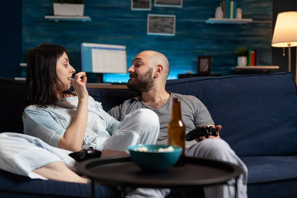 Engraçado casal relaxado sentado no sofá relaxante à noite rindo se divertindo — Fotografia de Stock