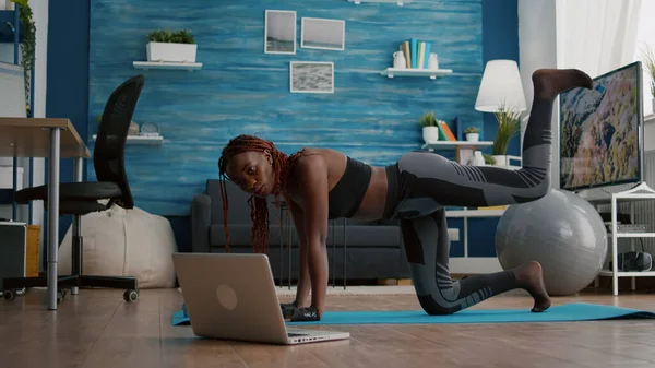 Спортивний спорт чорна жінка робить ранкову фітнес рутину дивитися фітнес тренування відео — стокове фото