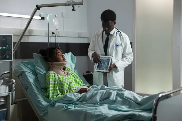 Dottore di etnia africana che mostra i risultati dei raggi X ai giovani pazienti — Foto Stock