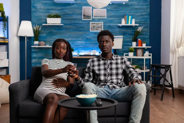 Siyahi çift, televizyon izleyen bir çocuk bekliyor. — Stok fotoğraf
