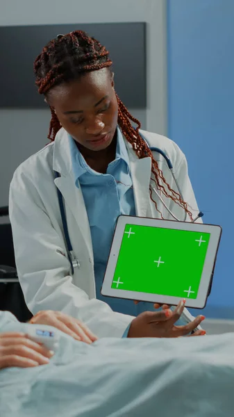 Femme spécialiste montrant écran vert sur tablette au patient — Photo