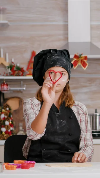 요리용 앞치마를 입은 손자가 전통적으로 집에서 만든 진저브레드 반죽을 xmas 로 만드는 쿠키 모양을 선택 한다 — 스톡 사진