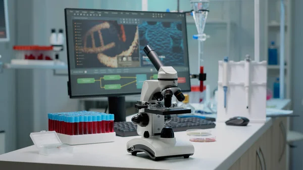 Microscopio científico sobre mesa de laboratorio con instrumentos de investigación — Foto de Stock