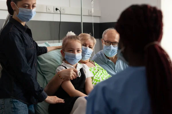 Чорна медсестра перевіряє пацієнта похилого віку, який пояснює лікування хвороби — стокове фото
