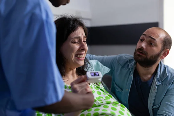 Медицинский ассистент держит за руку беременную женщину — стоковое фото