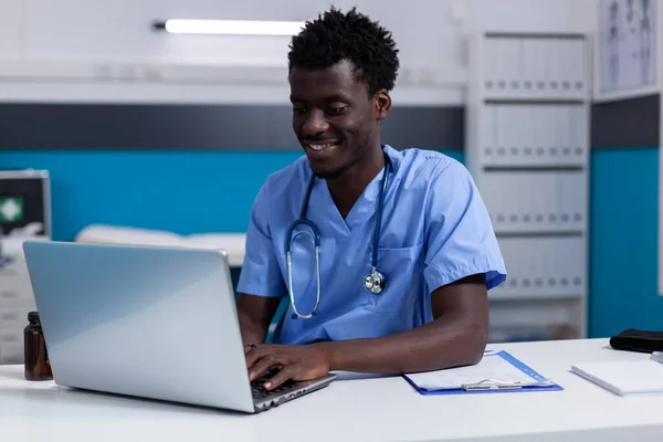 Jovem negro trabalhando como enfermeiro na clínica médica — Fotografia de Stock