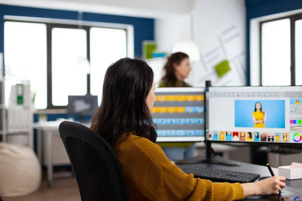 Fotograaf vrouw zit aan het bureau muziek te luisteren met behulp van PC in fotostudio — Stockfoto