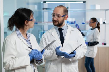 Hastane araştırma ekibi mikrobiyolojik araştırma sırasında virüs önlemeyi tartışıyor