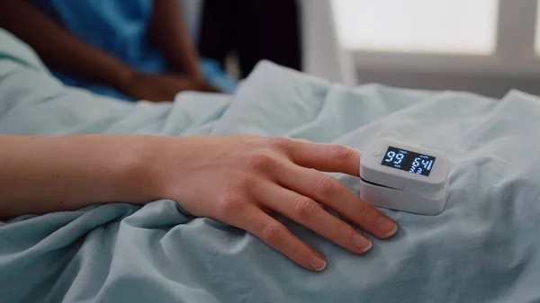 Close up of hospitalized woman with finger heart rate monitor showing pulse — Stock Photo, Image