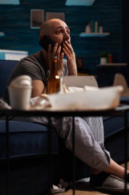 Mutsuz, bunalımlı, kronik hastalıklı bir adam akıllı telefondan trajedi haberleri okuyor.
