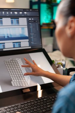 Profesyonel kadın mimar inşaat planı üzerinde çalışıyor.