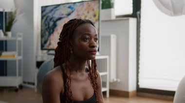 Sağlıklı yaşam tarzından hoşlanan atletik zenci kadın portresi yoga İsviçre topunda oturuyor.