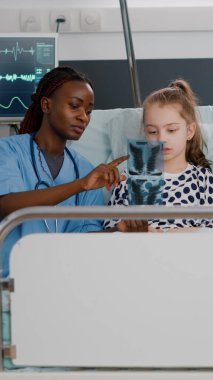 Afro-Amerikan hemşire akciğerlerine radyografi gösteriyor. İyileşme uzmanlığını açıklıyor.