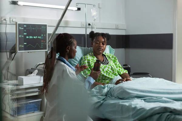 Afrikaans-Amerikaanse mensen praten over behandeling op ziekenhuisafdeling — Stockfoto